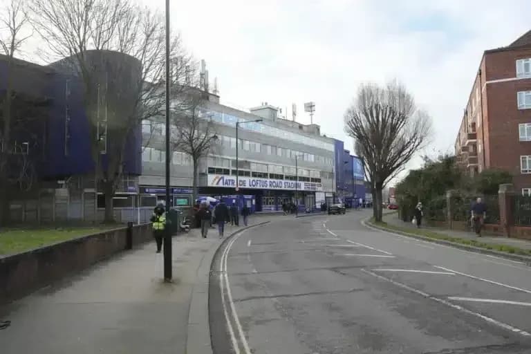 Exterior view of Loftus Road Stadium with pedestrians