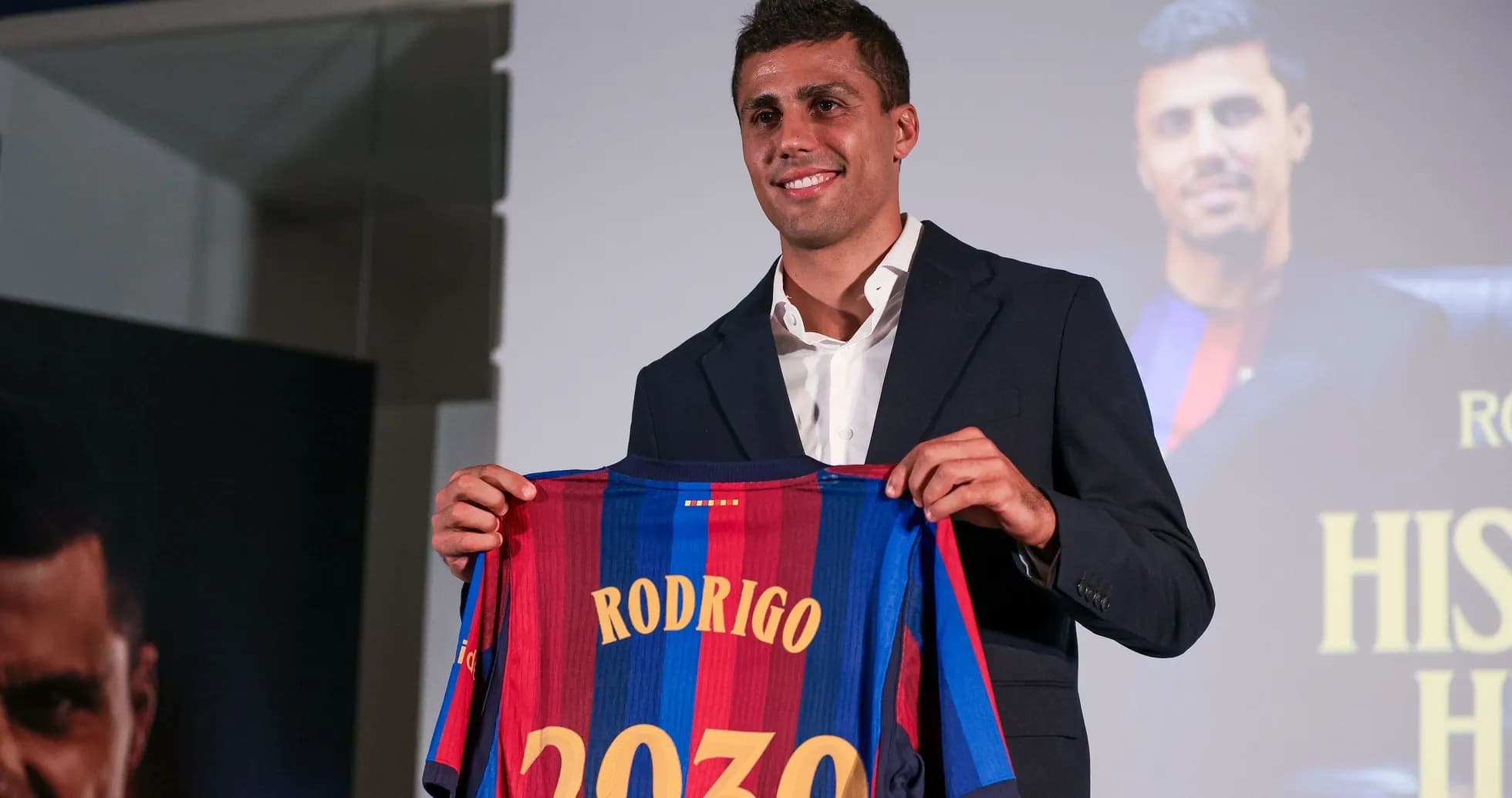 Player holding Barcelona jersey at press conference
