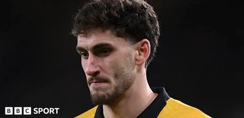 Player in yellow jersey looking thoughtful on field