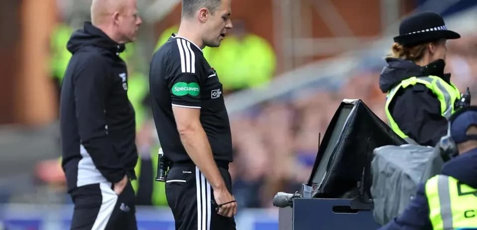 Referee reviewing decision at VAR monitor during match