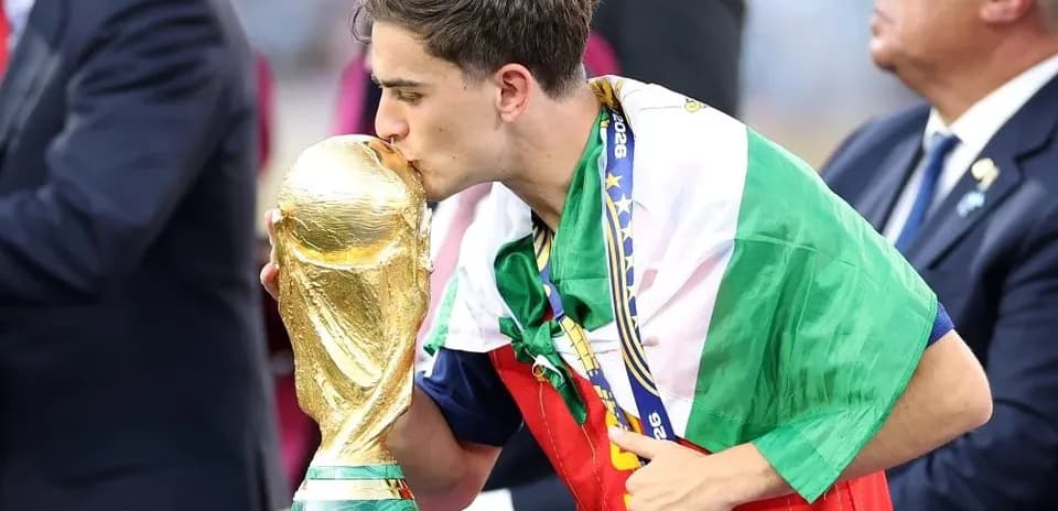Player kissing the World Cup trophy on stage