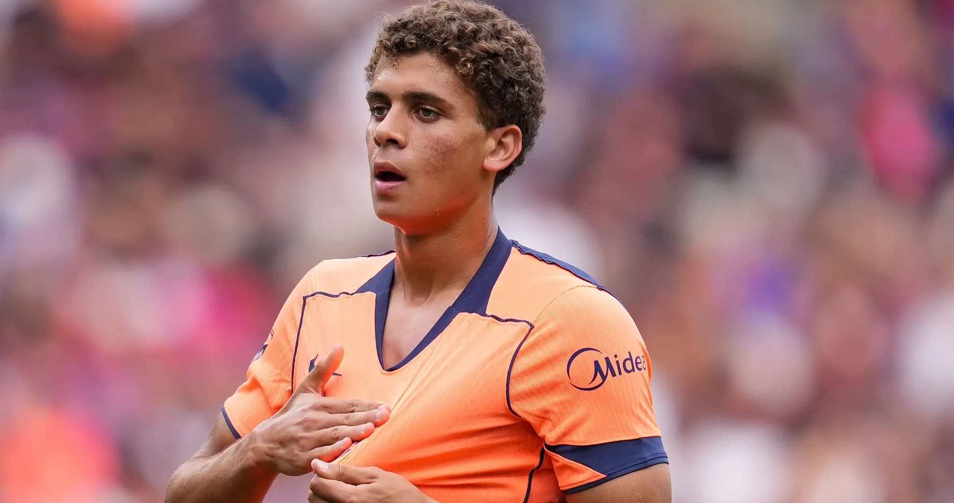Player wearing orange jersey during match preparation