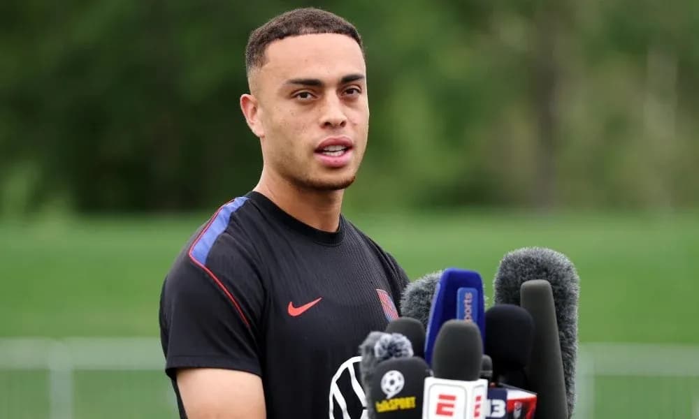 Player speaking at press conference with microphones