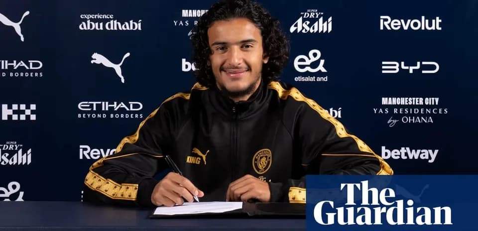 Player signing contract at press conference table