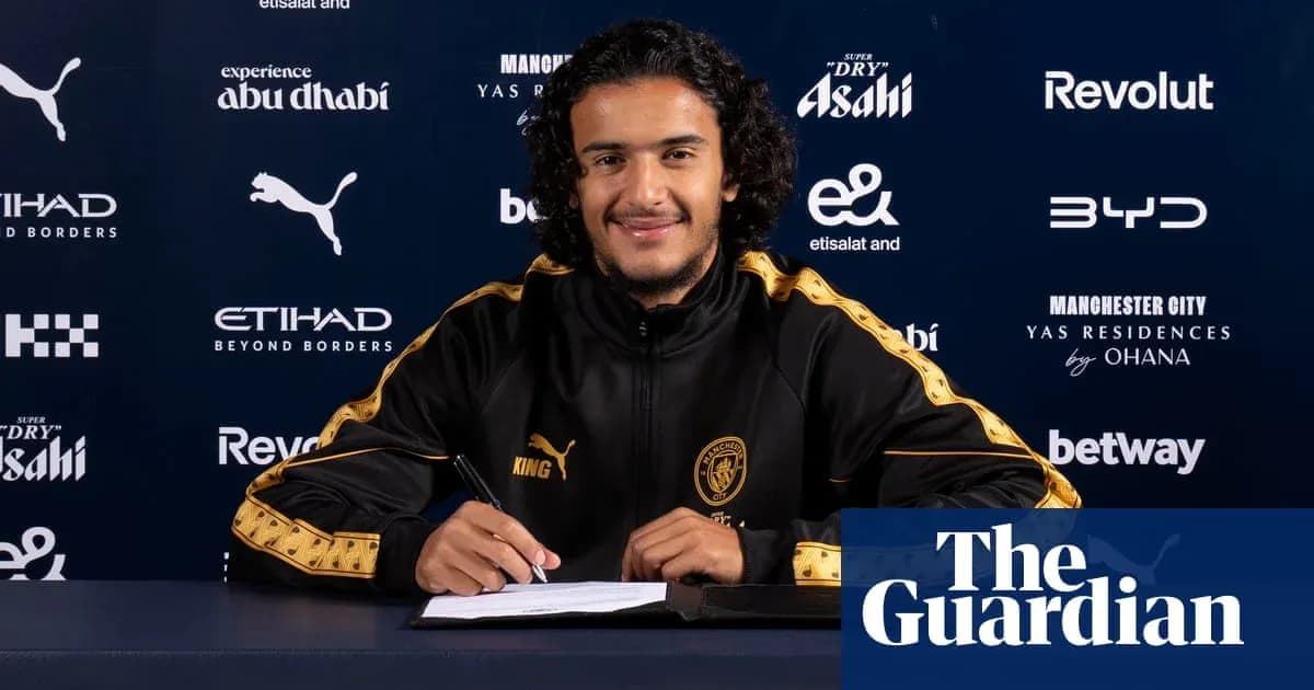 Player signing contract at press conference table