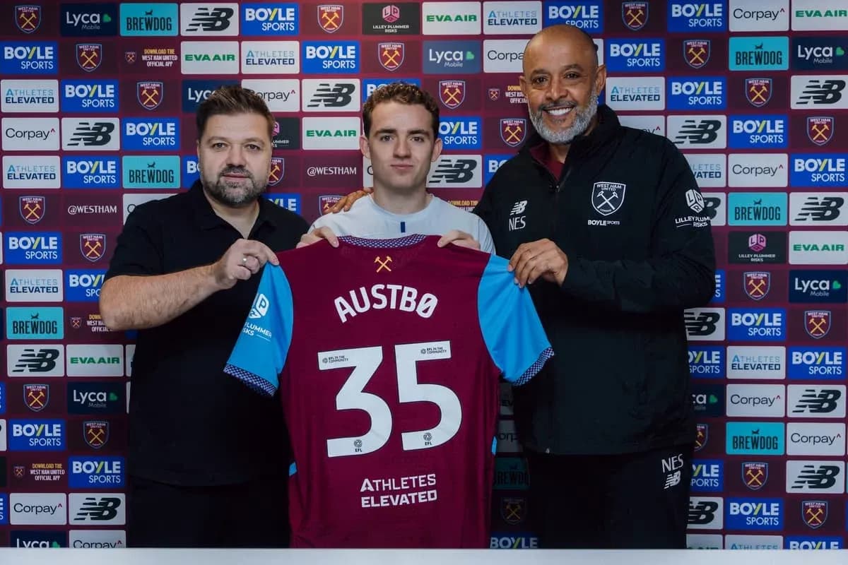 Player holding jersey during signing ceremony with staff