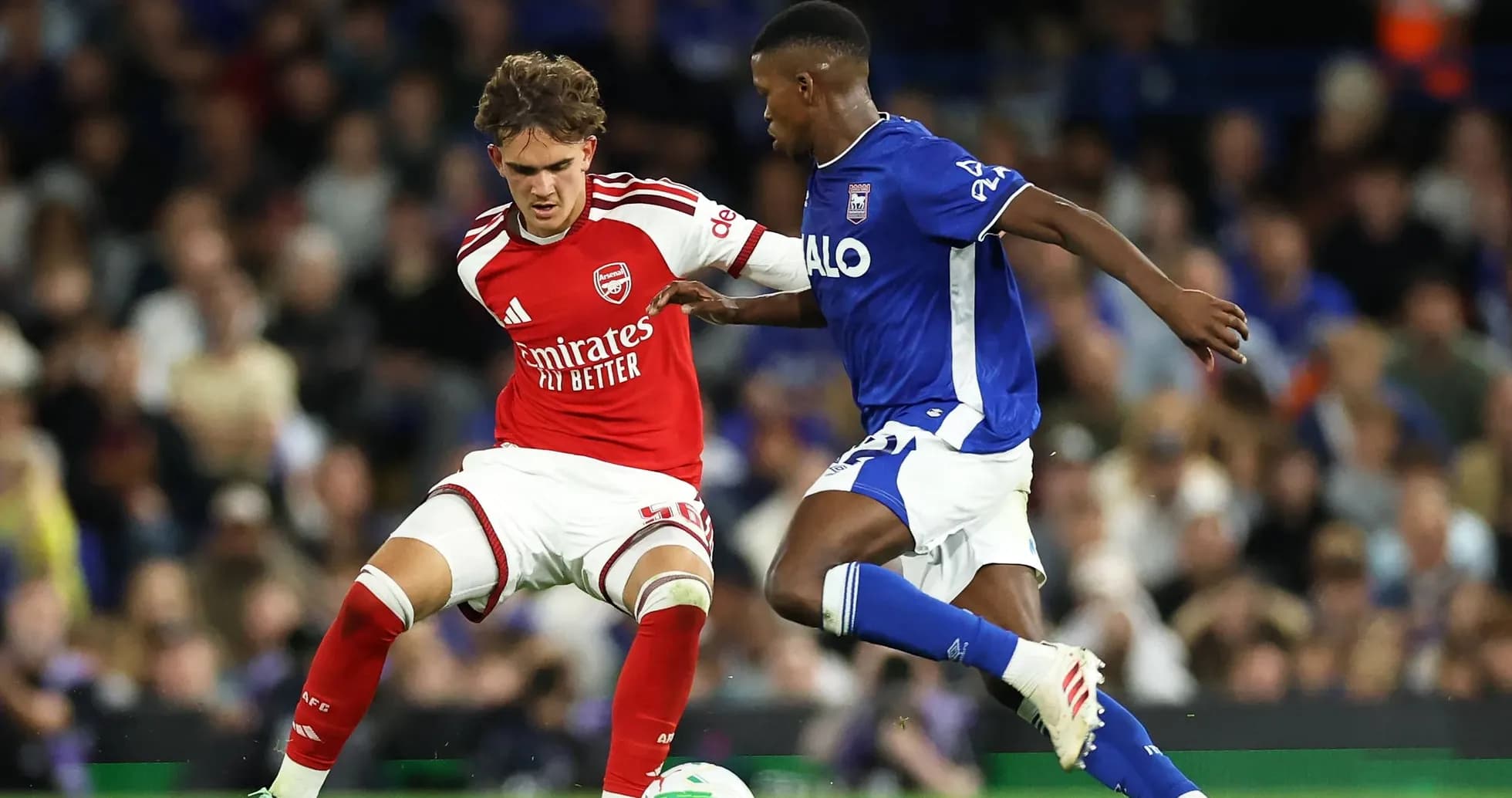 Player in red and player in blue contesting the ball