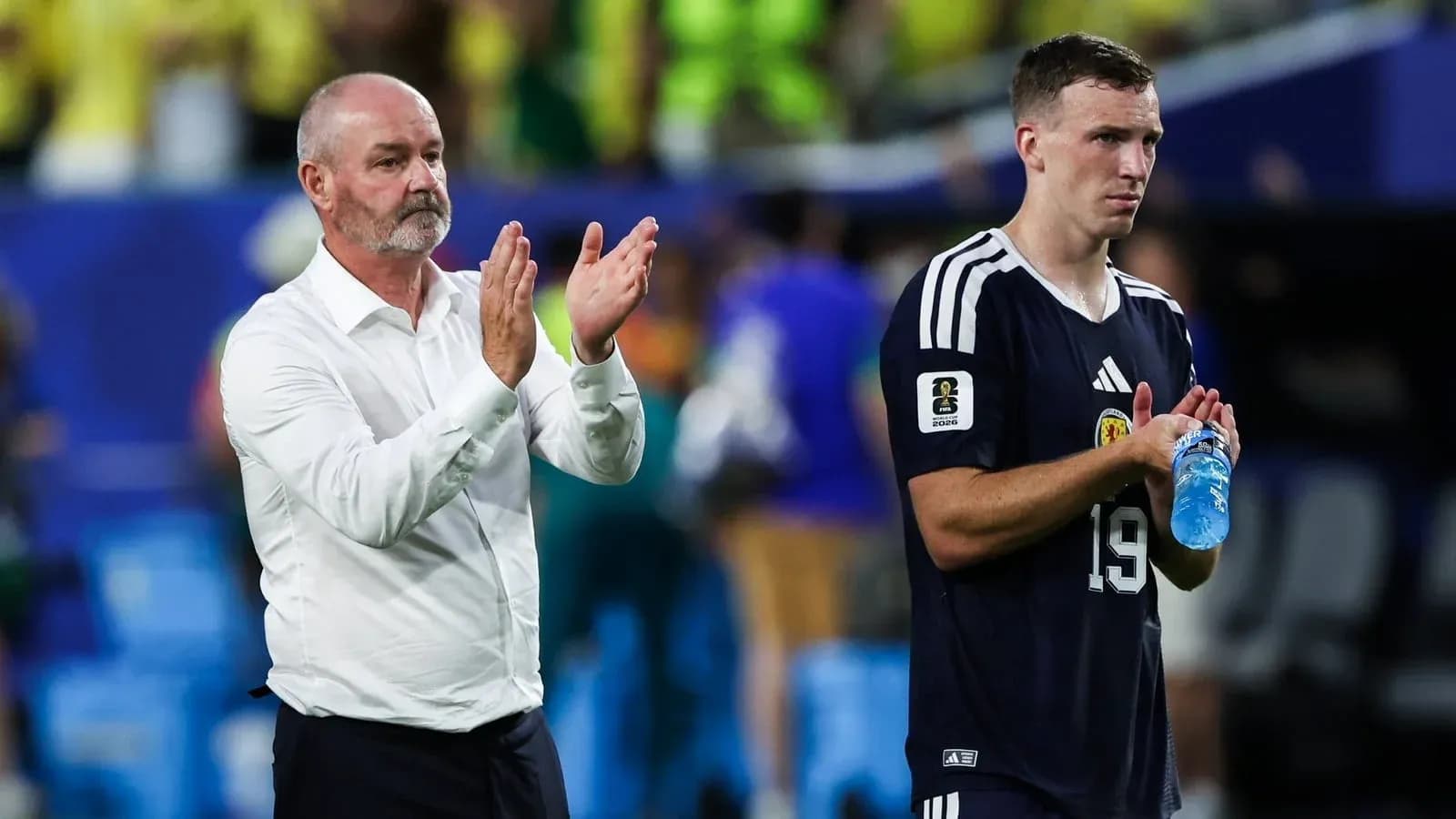 Coach and player applauding fans after match