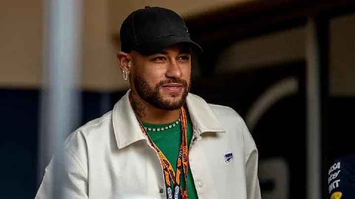 Man with beard and cap smiling in casual attire