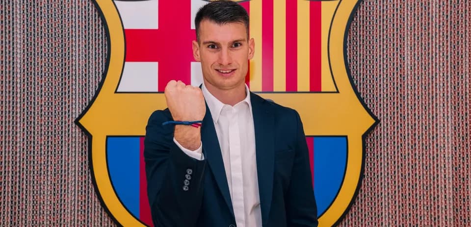 Player posing with fist raised in front of FC Barcelona logo