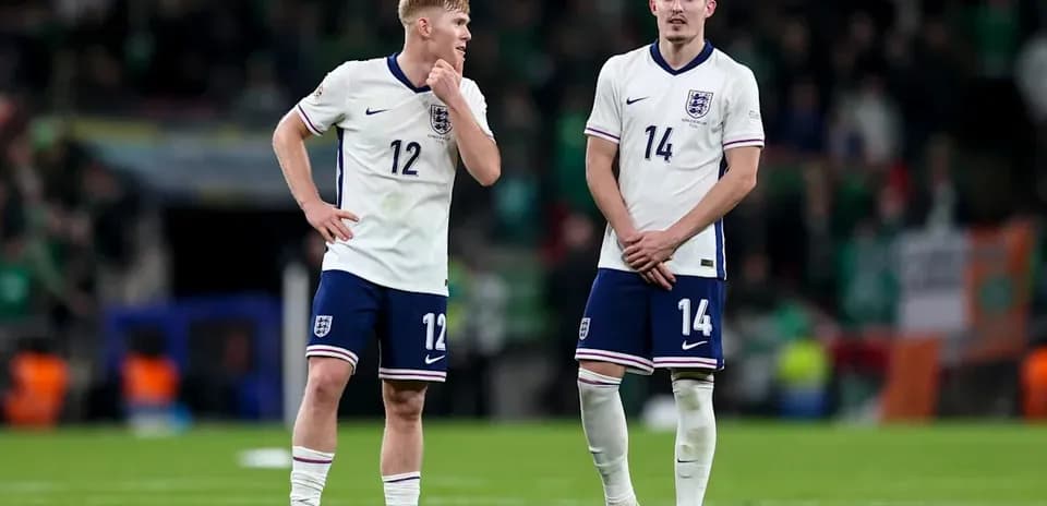 Two England players standing on the pitch after match