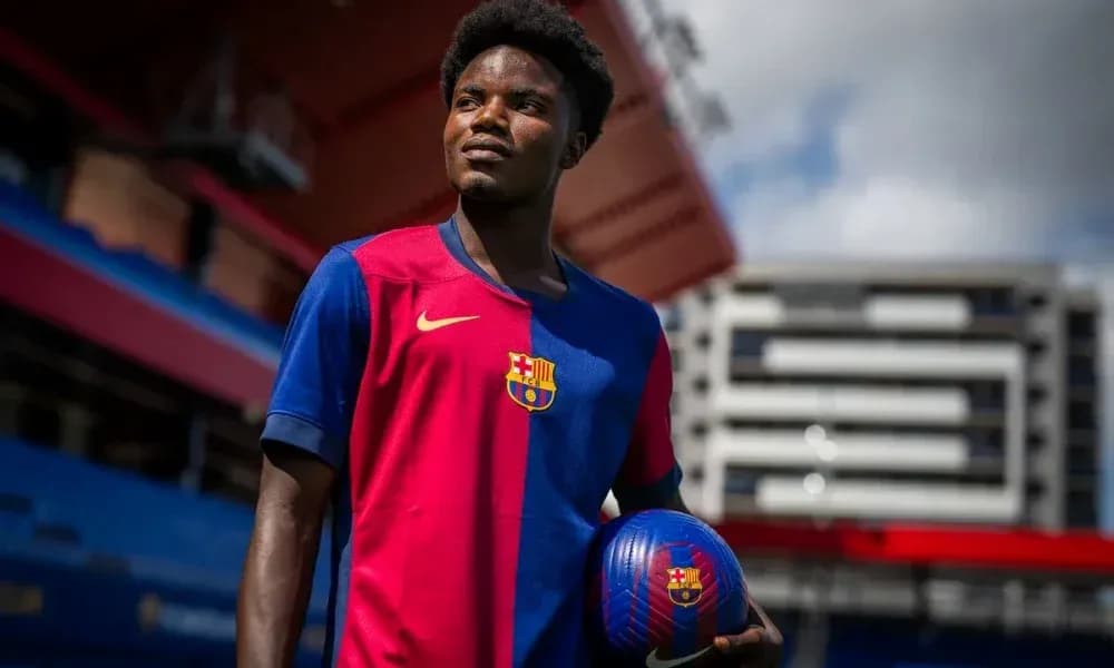 Player in Barcelona jersey holding a soccer ball