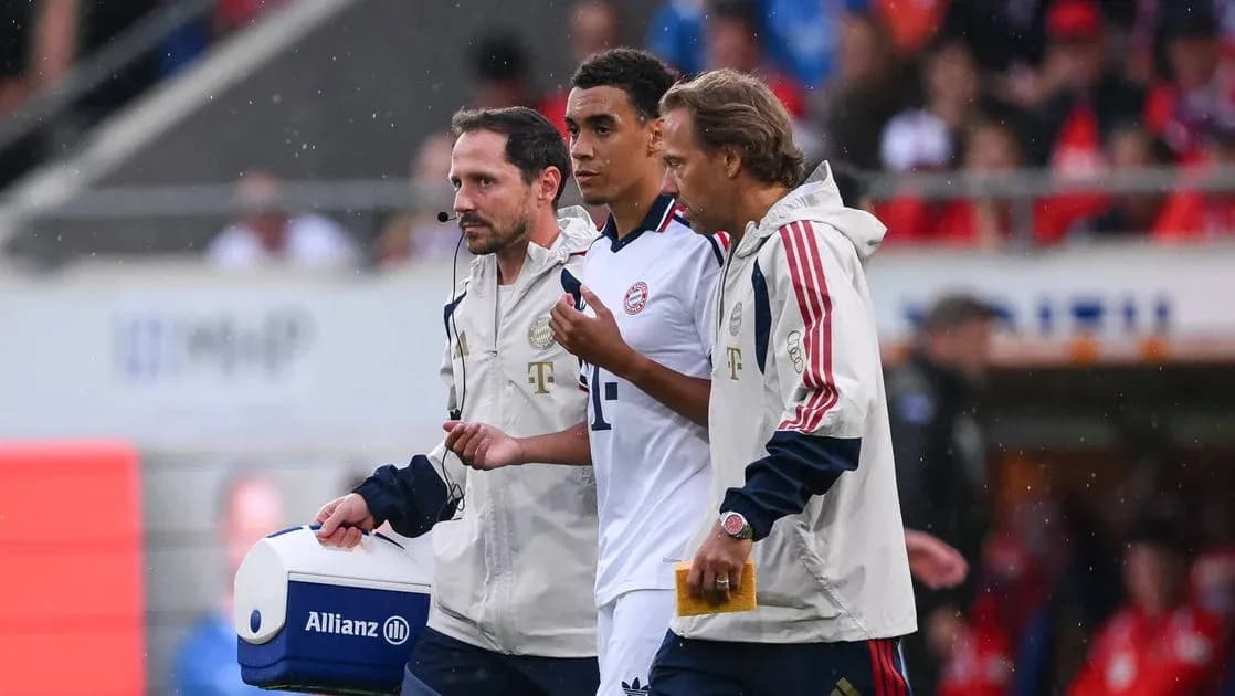 Player being assisted off the field by staff