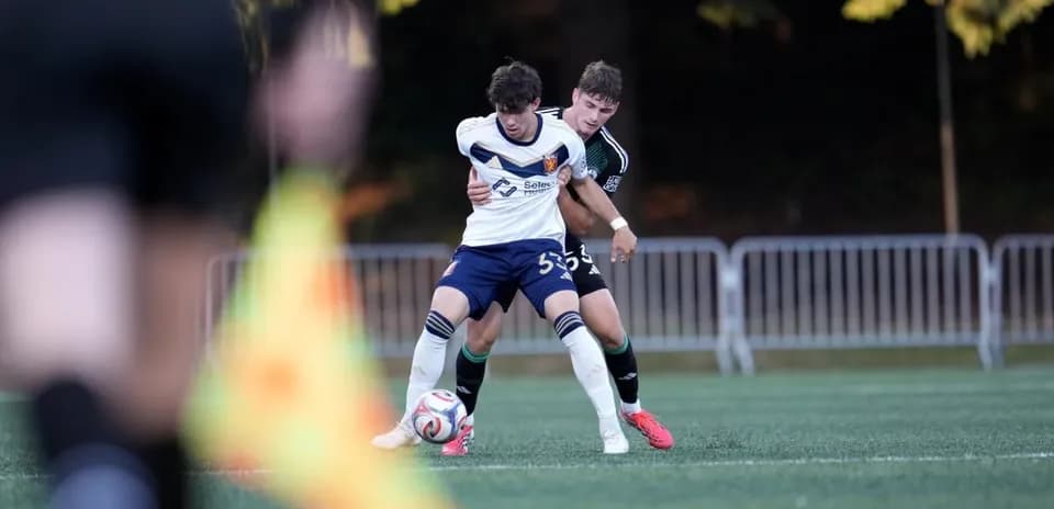 Two players competing for the ball in football