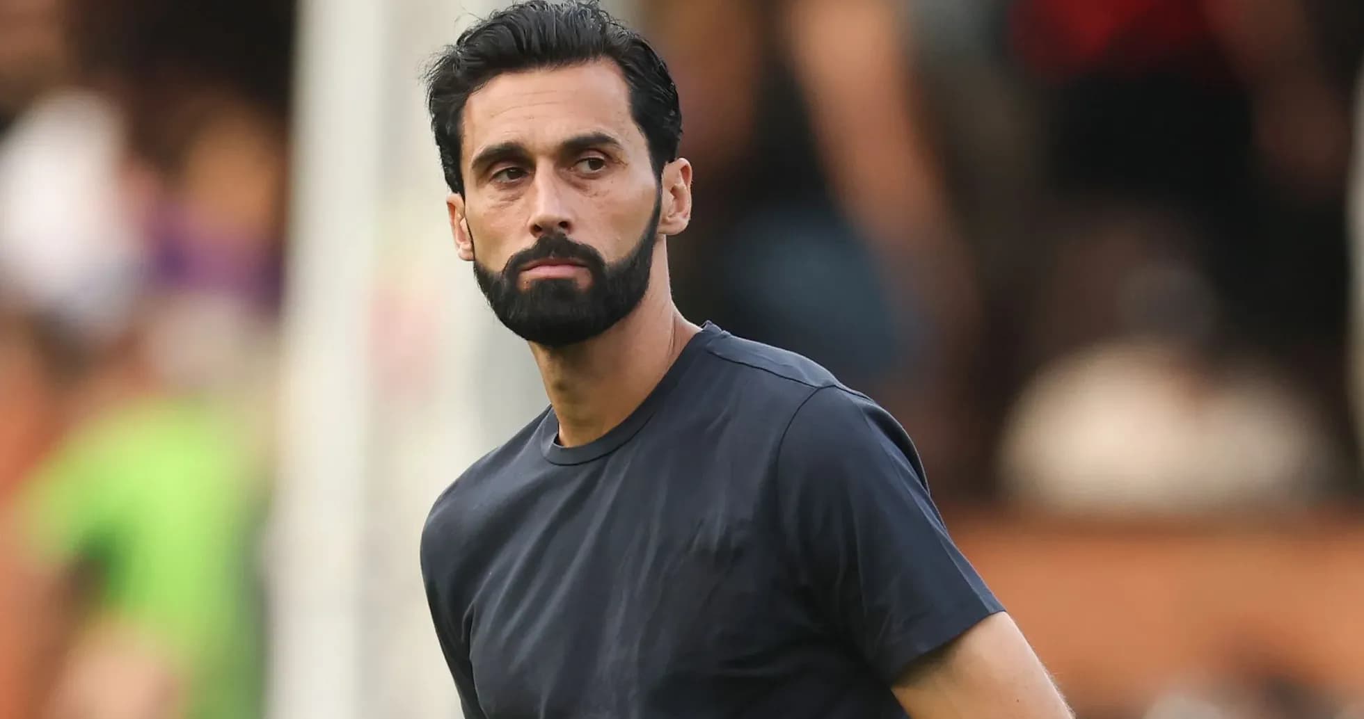 Man in dark shirt observing a match