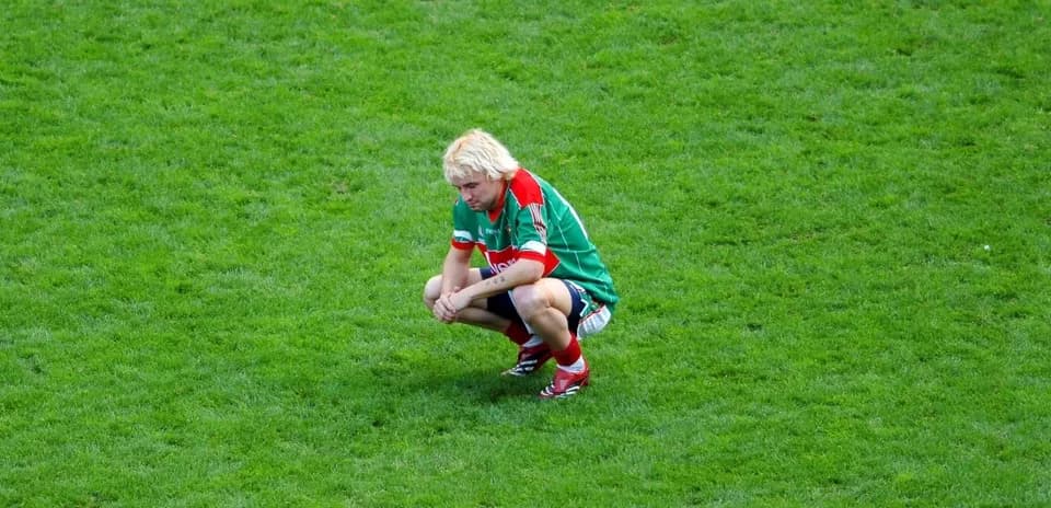Player squatting on the field after a match