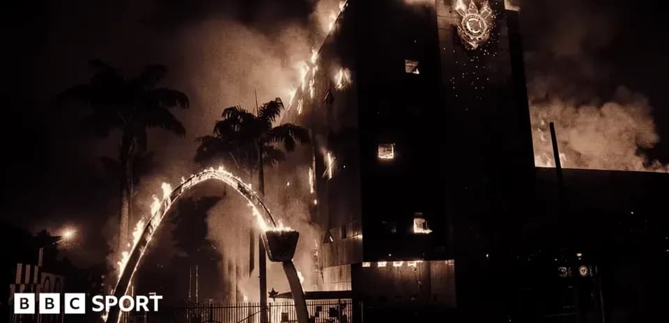 Building engulfed in flames with burning palm trees