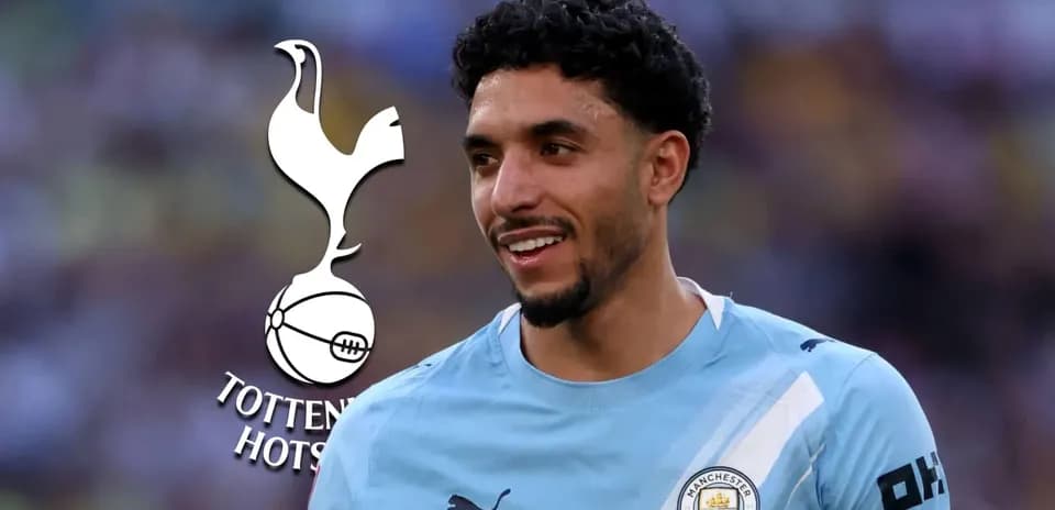 Player smiling in Manchester City jersey with logos
