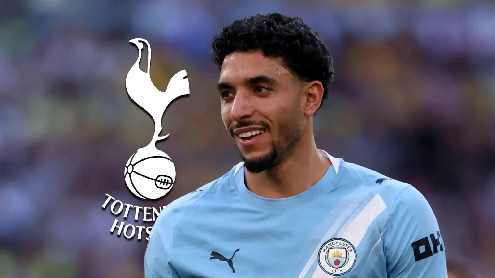 Player smiling in Manchester City jersey with logos