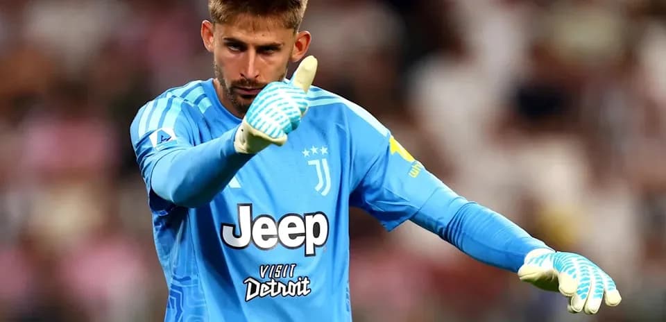 Goalkeeper in blue jersey signaling during match