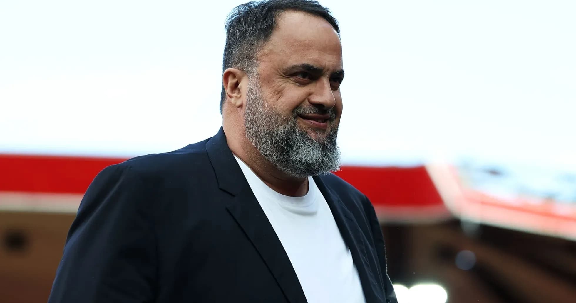 Man in black blazer walking at stadium entrance