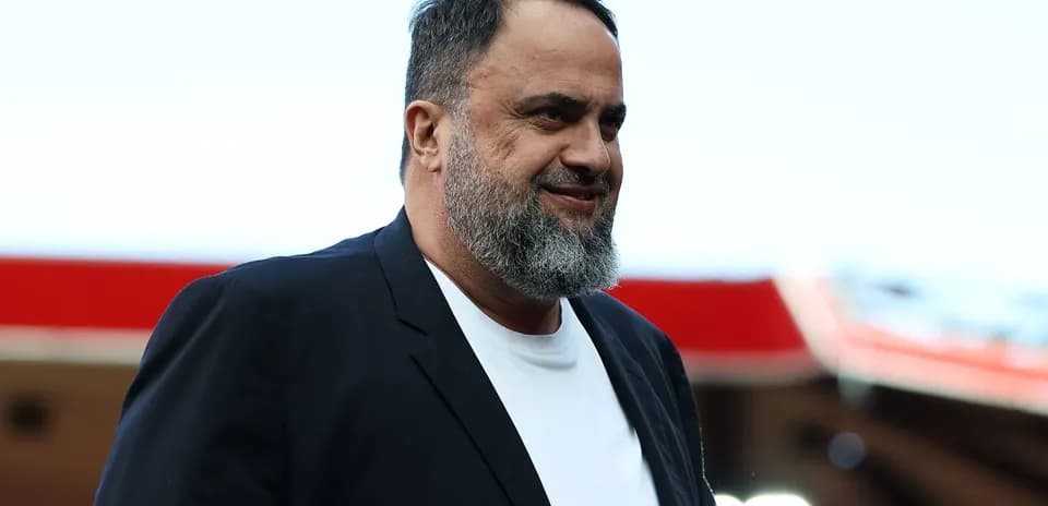 Man in black blazer walking at stadium entrance