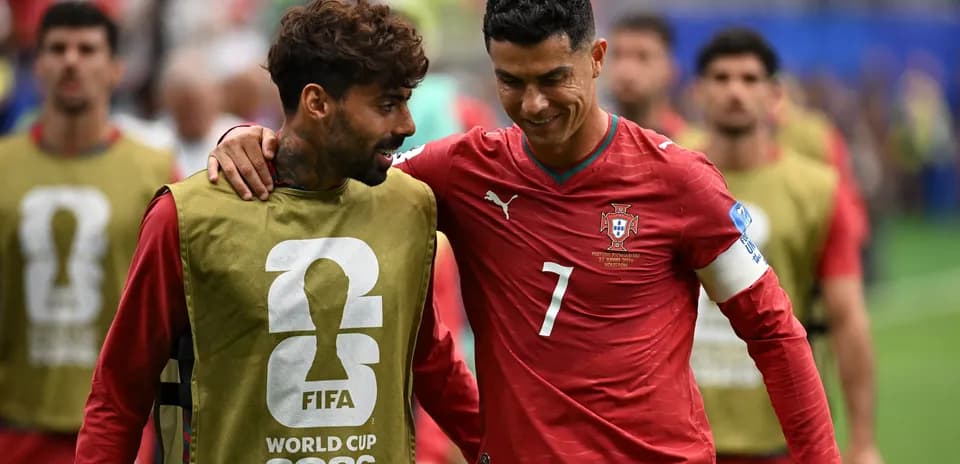 Two players in Portugal kits interacting on field
