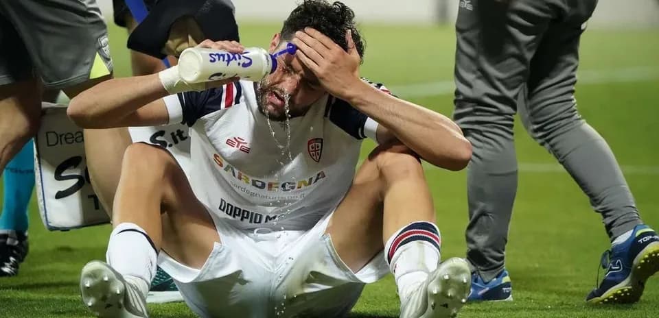 Player sitting on field pouring water on face