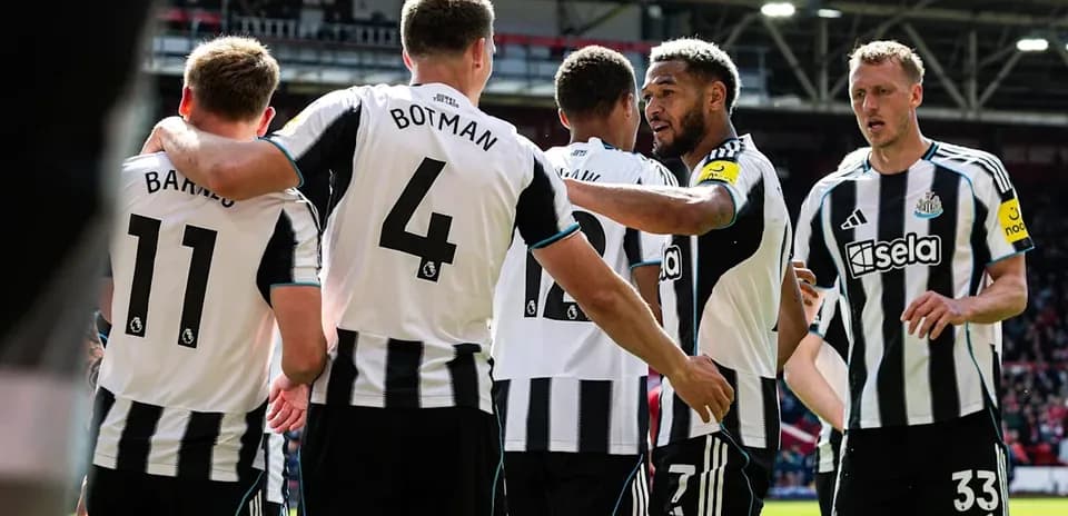 Newcastle players celebrating a goal on the field