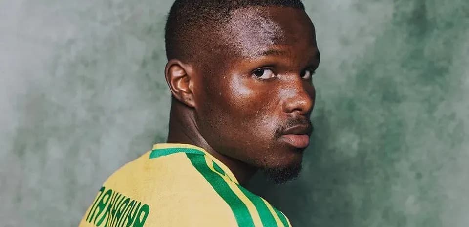 Player wearing yellow jersey against green background