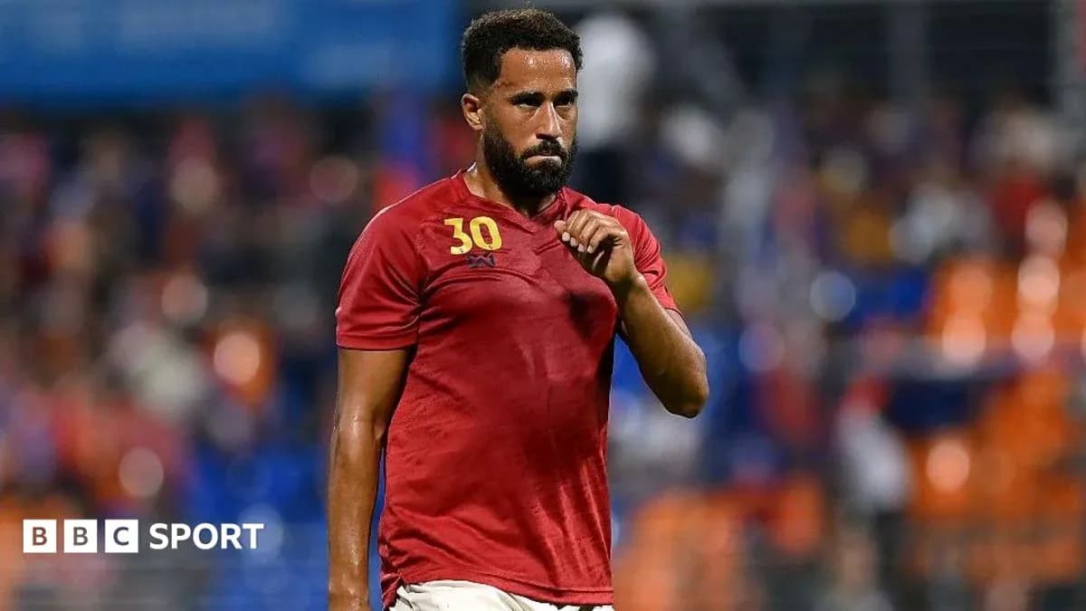 Player in red jersey walking on the pitch