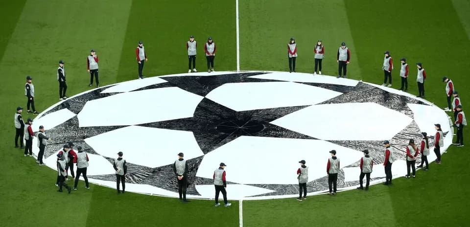 Ground staff preparing UEFA Champions League logo on pitch