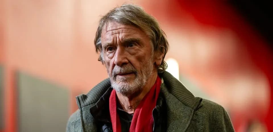 Man with gray hair wearing a coat and scarf