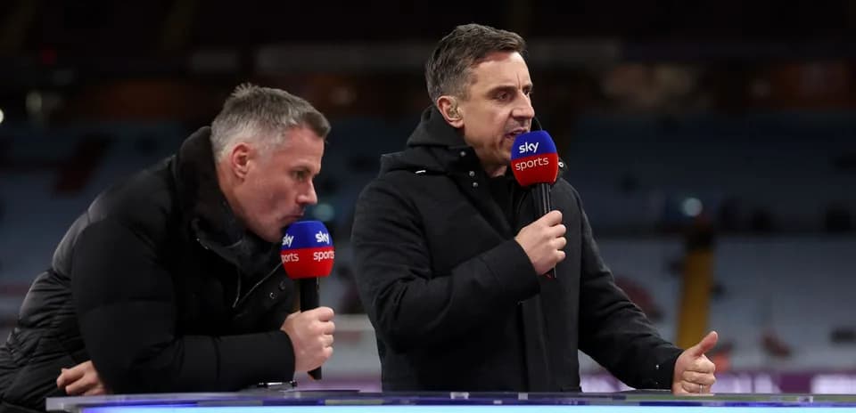 Two sports analysts speaking at a broadcast desk