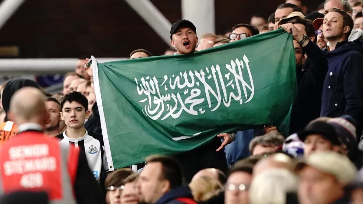 Fans holding a Saudi Arabian flag in stadium