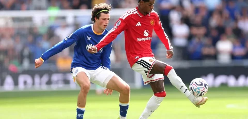 Manchester United player dribbling past opponent