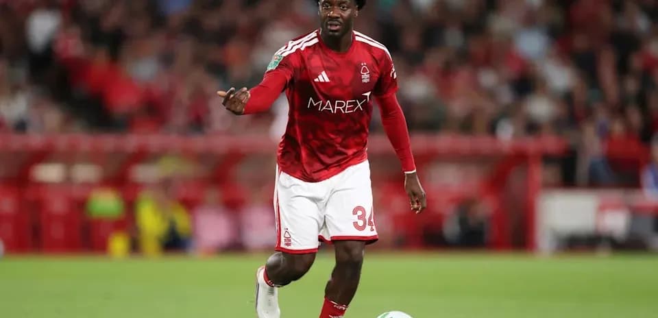 Player in red kit directing play on field