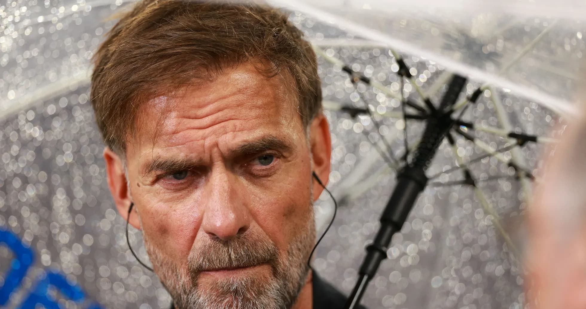 Coach speaking under an umbrella during rain