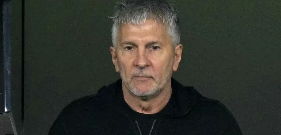 Man with gray hair in dark jacket looking ahead
