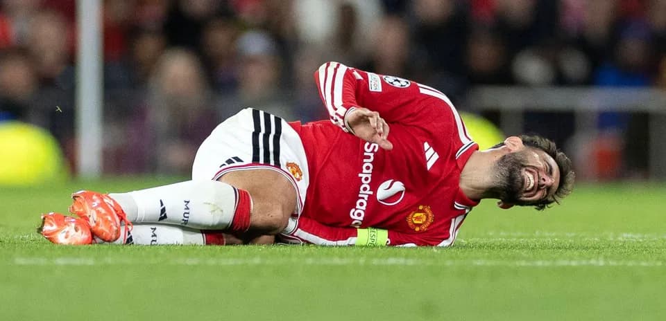 Player lying on pitch in Manchester United kit