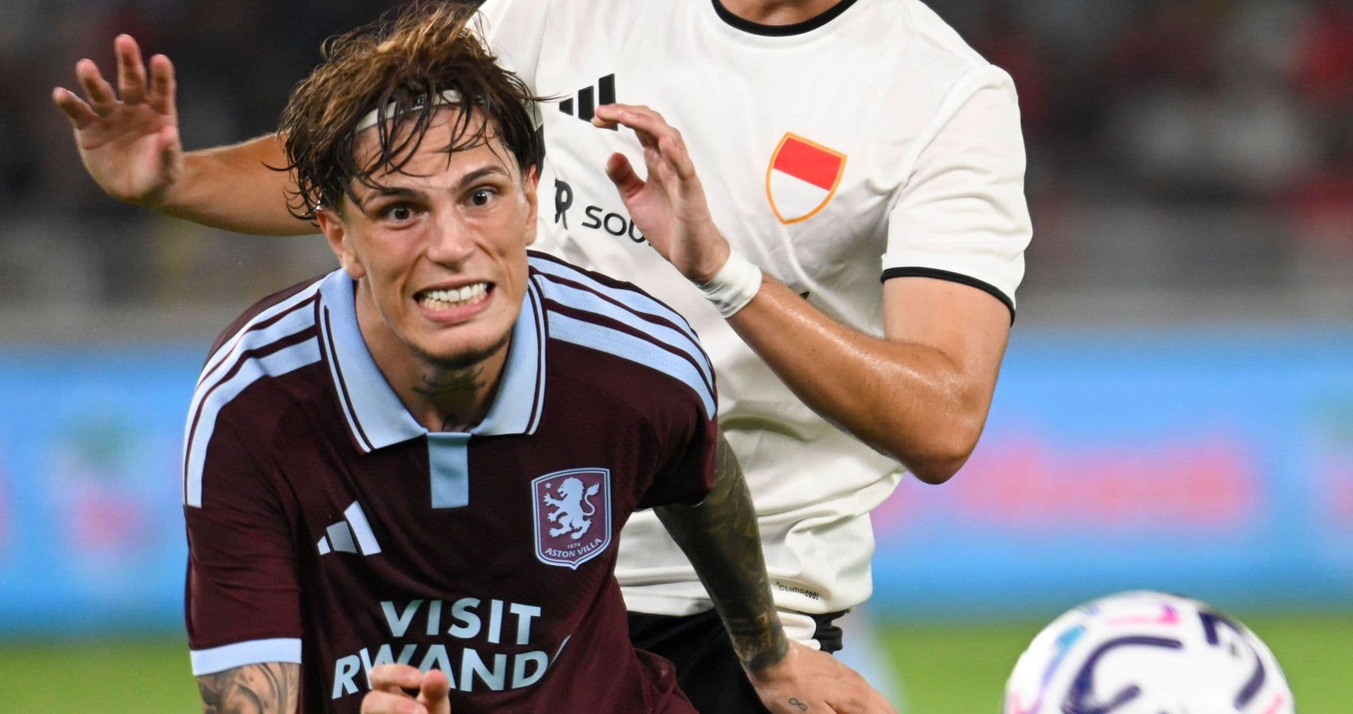 Player from Aston Villa challenged by opponent during match