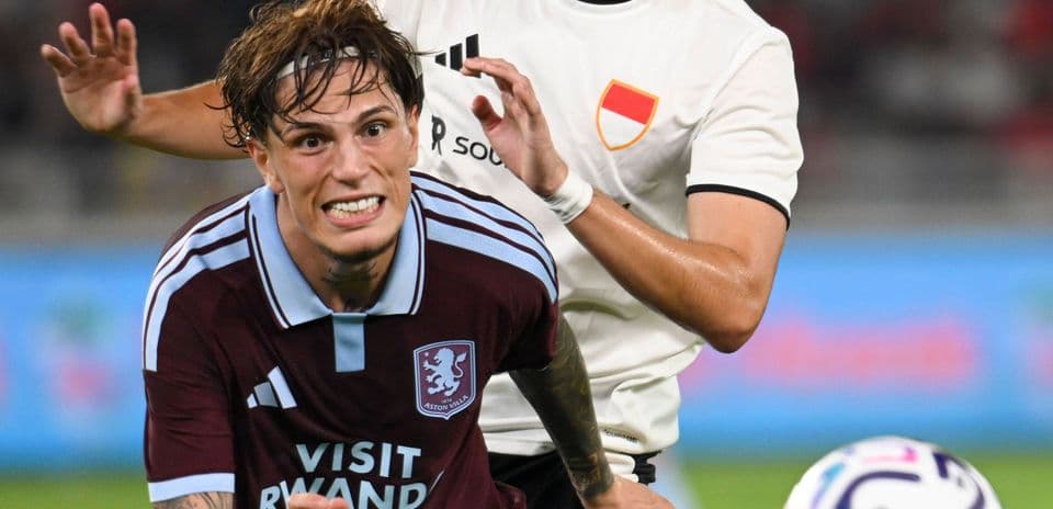 Player from Aston Villa challenged by opponent during match