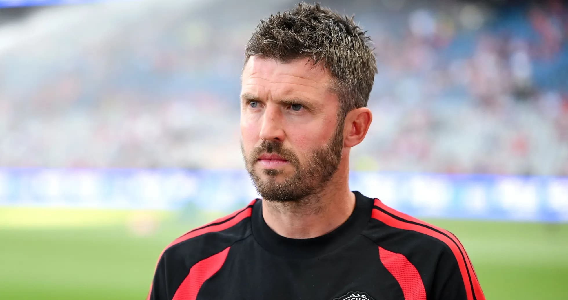 Coach in Manchester United training kit on pitch