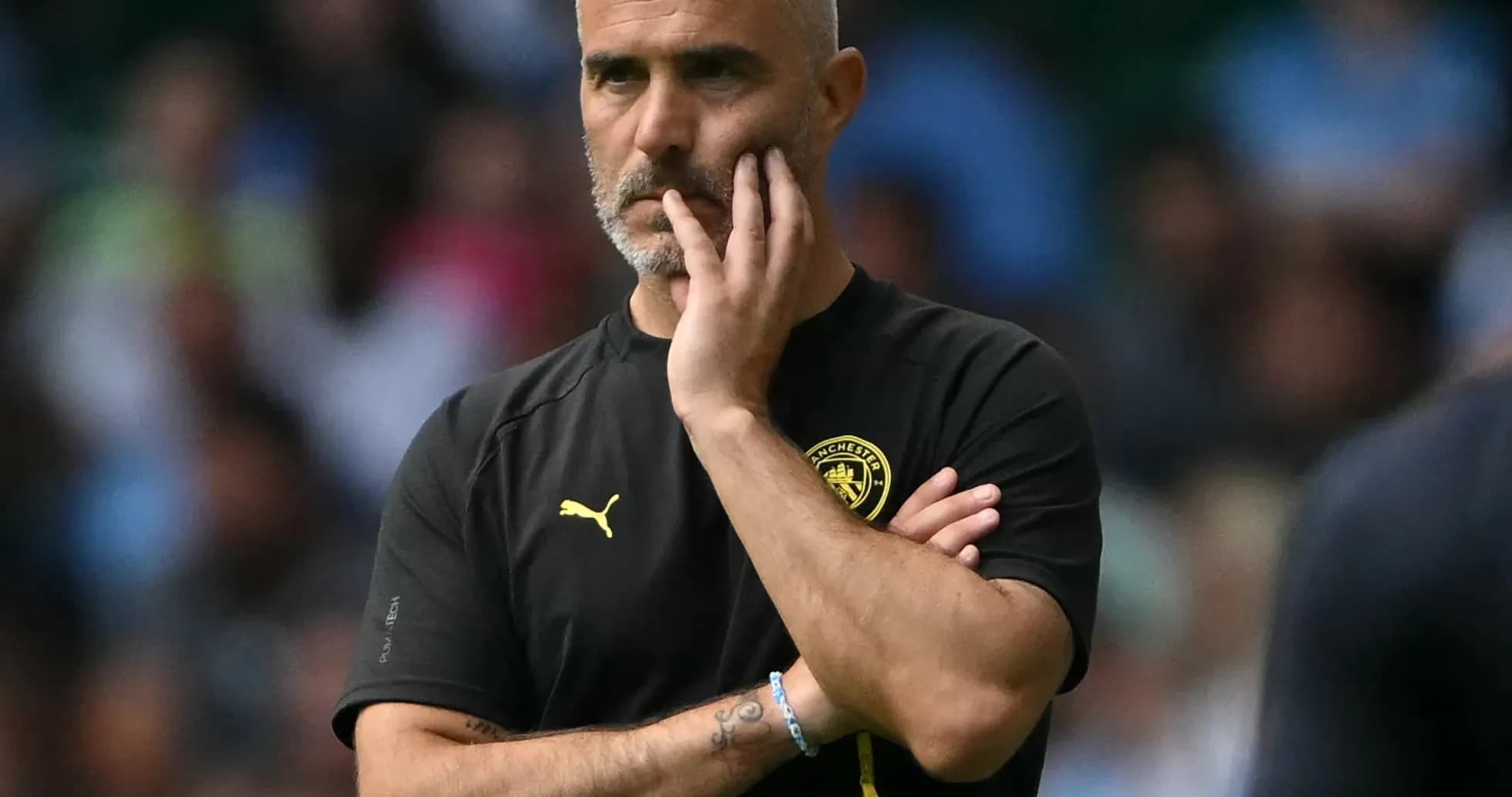 Manager observing the match with thoughtful expression