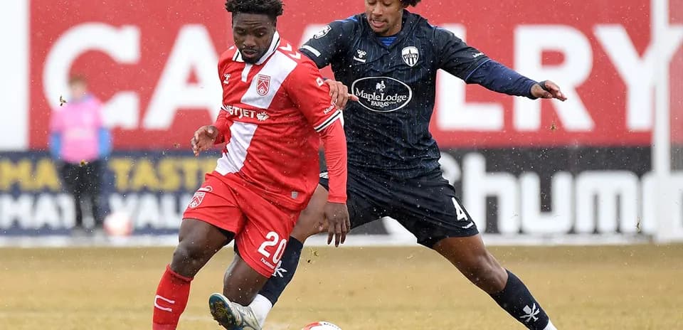 Two players competing for the ball in match