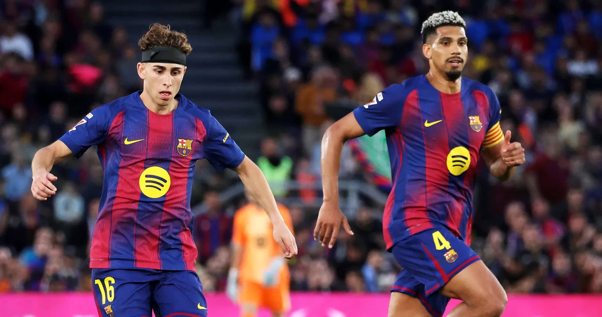 Two FC Barcelona players running on the field