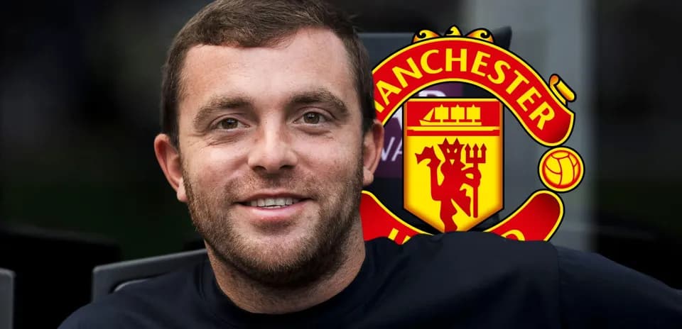 Man smiling with Manchester United logo in background