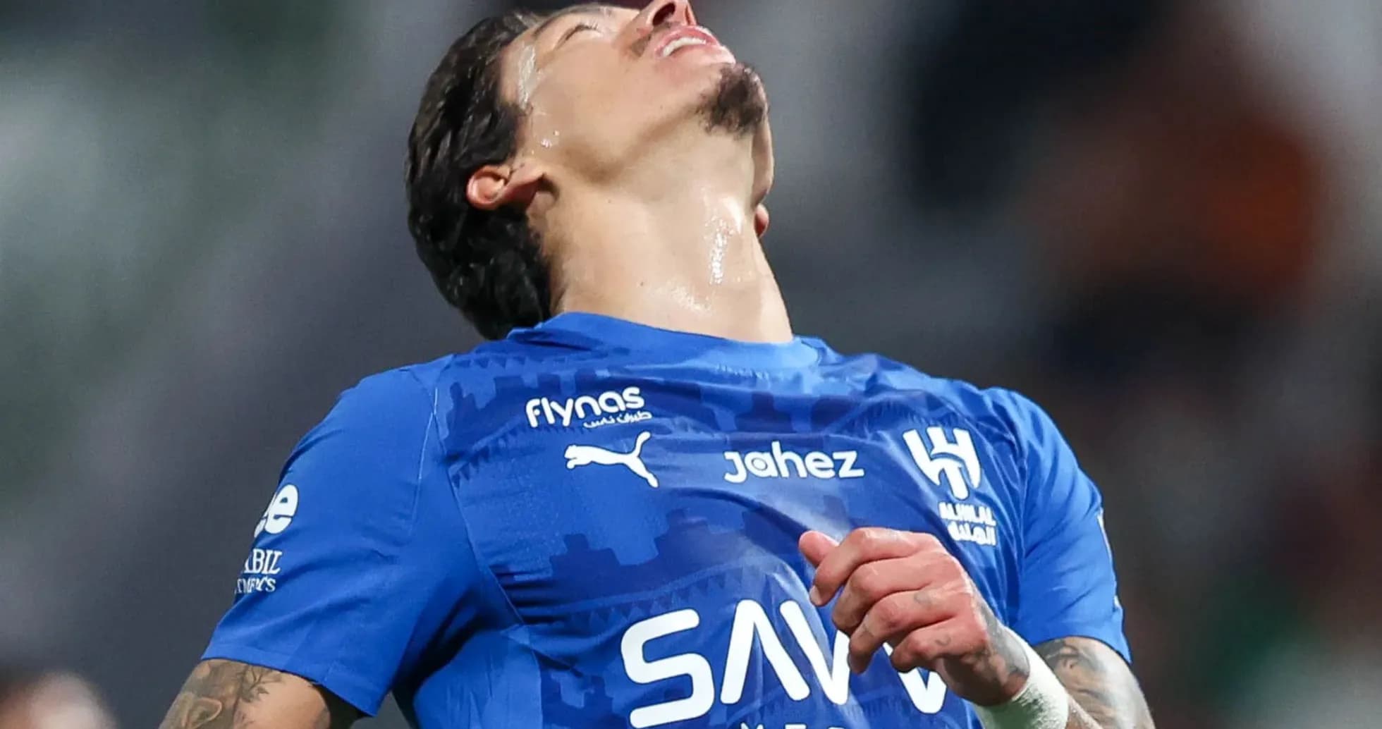 Player in blue jersey expressing frustration during match