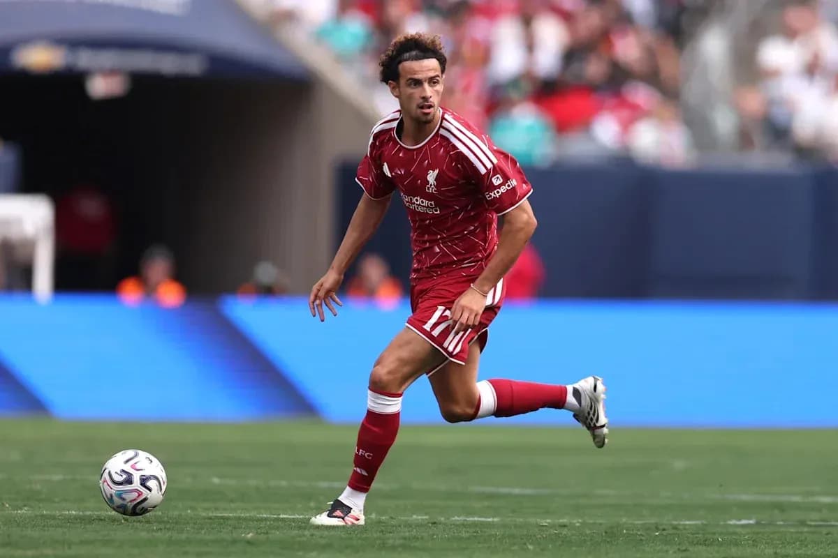 Player in Liverpool kit dribbling ball on field