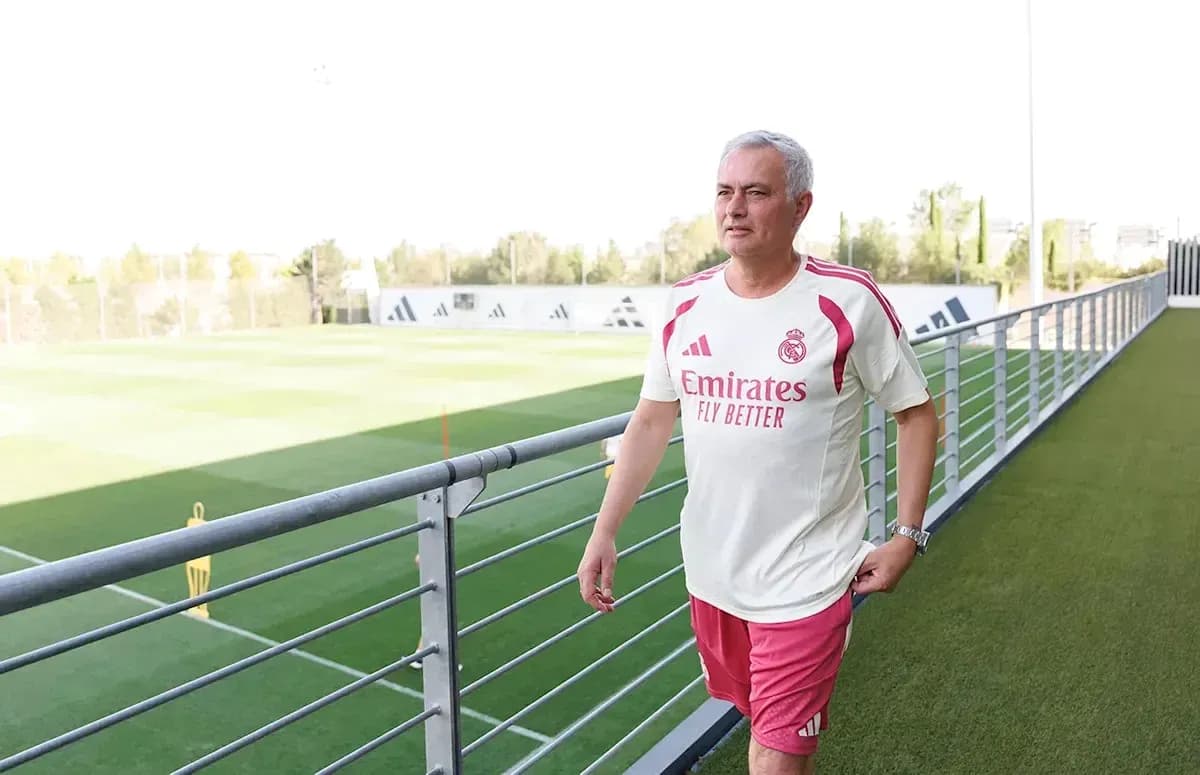 Coach walking on training pitch at facility